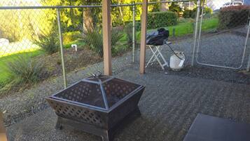 A patio area with a Galaxy S23 Ultra branded grill, a folding chair, and a table.