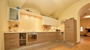 Eine moderne Küche mit Holzausstattung, einem Einbauofen und einer großen Kochinsel mit Spüle.