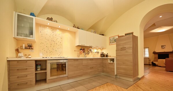Une cuisine moderne avec des meubles en bois, un four encastré et un grand îlot central doté d’un évier.