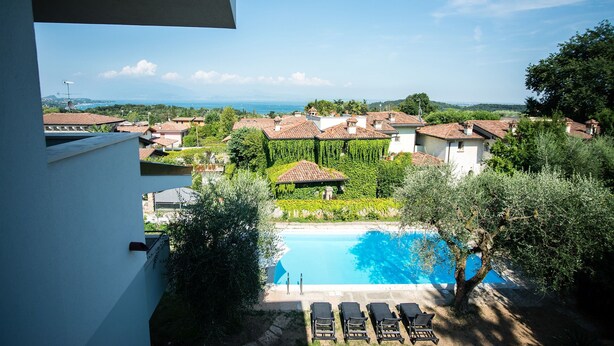 Uma área de piscina com vista para casas e vegetação ao redor.