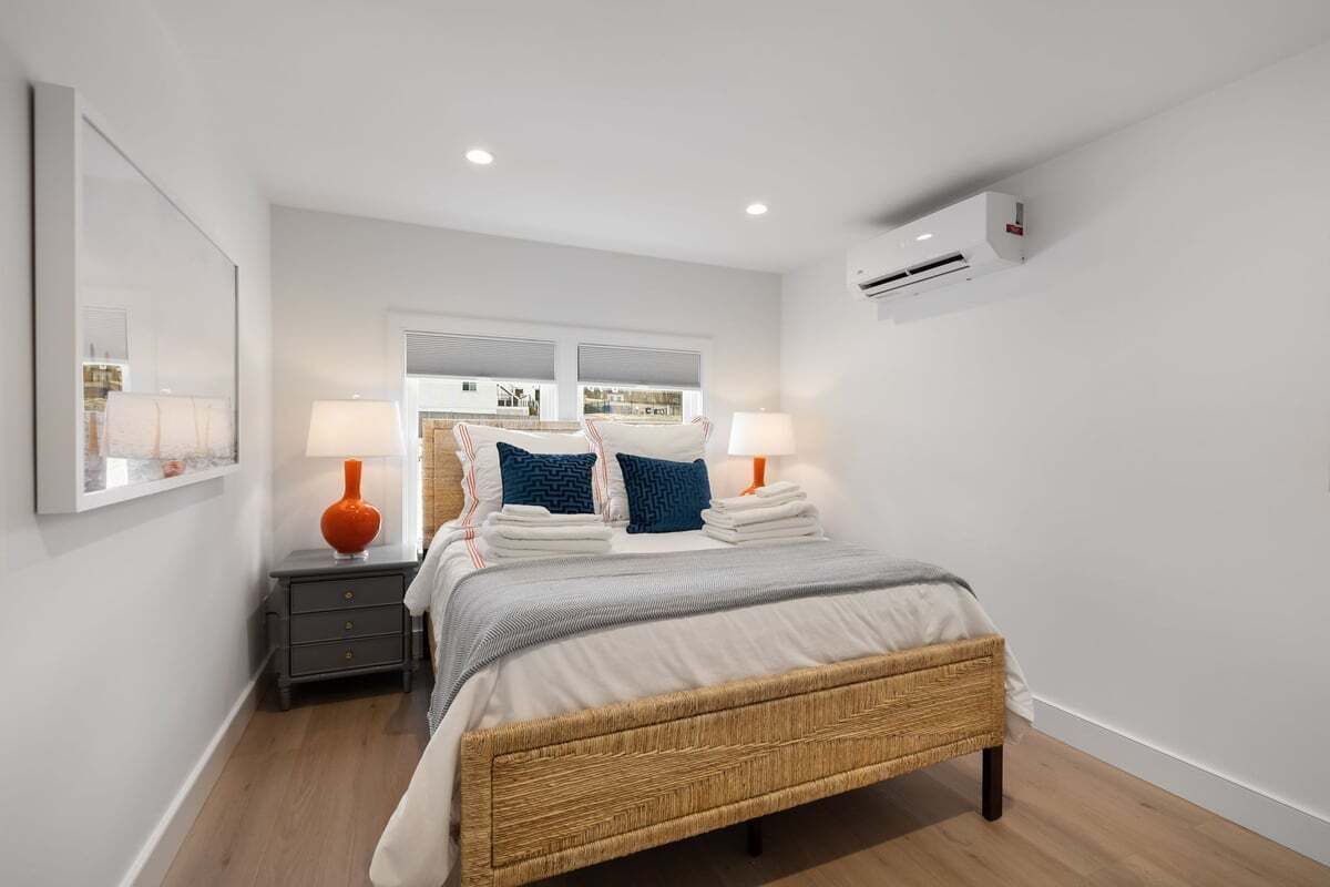 Een moderne slaapkamer met een bed, nachtkastjes en een raam.