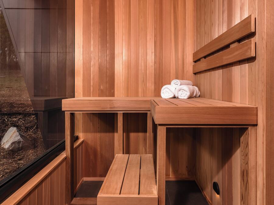 Una sauna de madera con un banco y un estante con toallas.