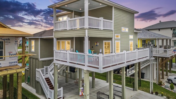 A multi-story building with balconies and a covered outdoor area. - Canal Front | Gated Community, Firepit & Decks (Port Bolivar)