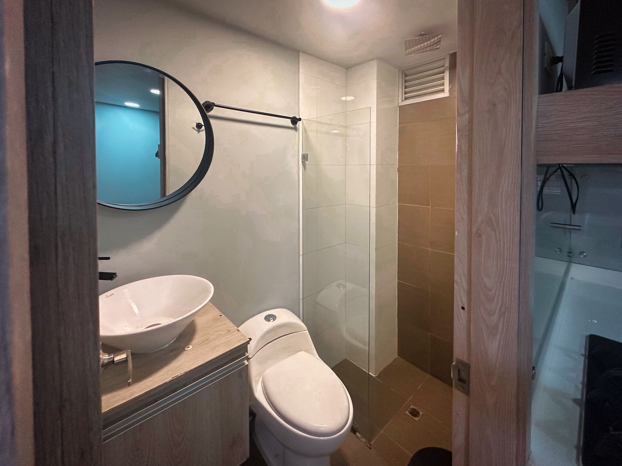 A bathroom with a sink, toilet, and a glass-enclosed shower area.