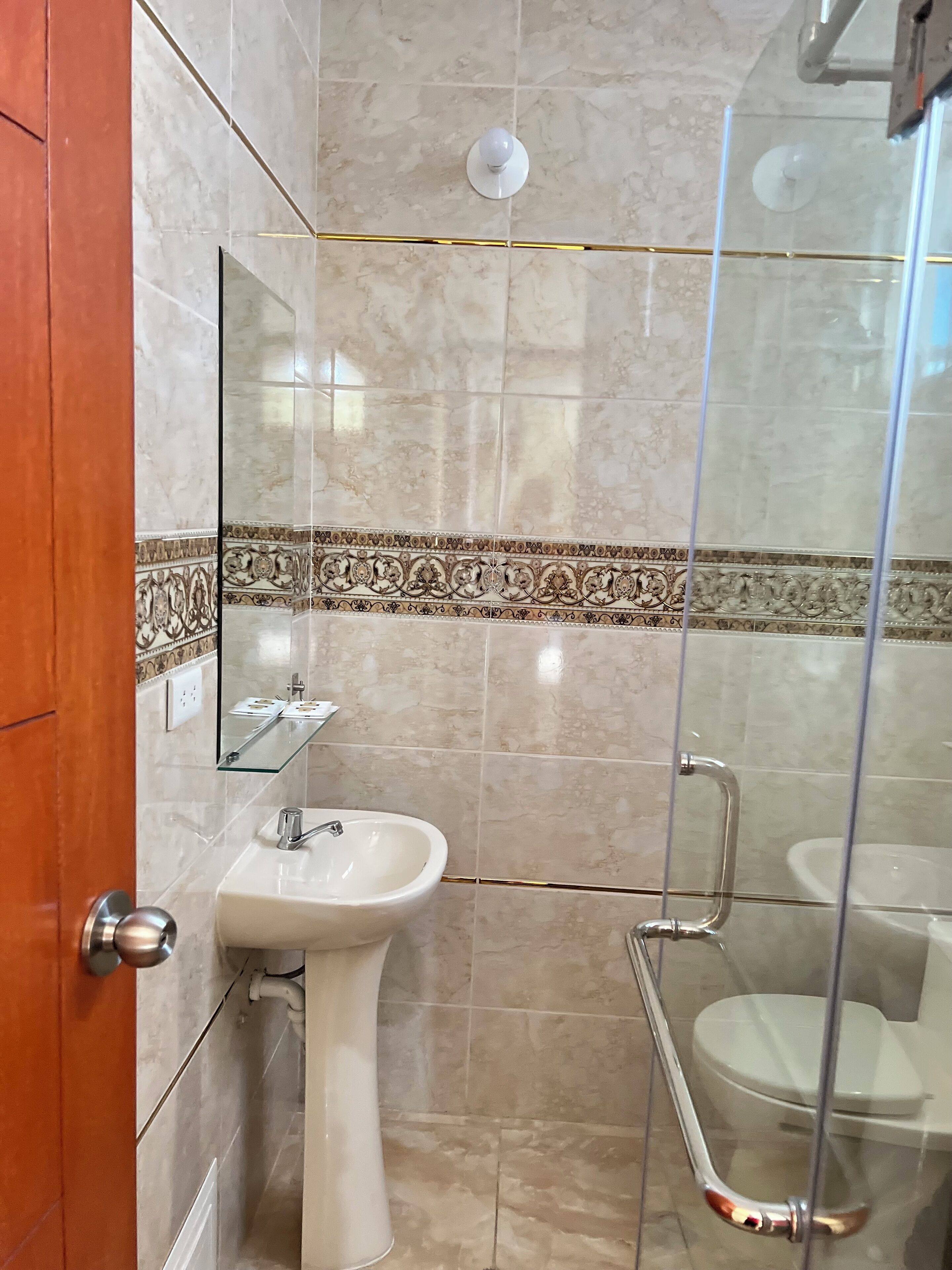 Een badkamer met een wastafel, spiegel en toilet.