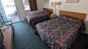 A hotel room with two beds, a desk, a chair, and a window with curtains. - Relax Inn (New Castle)