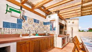 A kitchen with wooden cabinets, a sink, and a tiled backsplash.