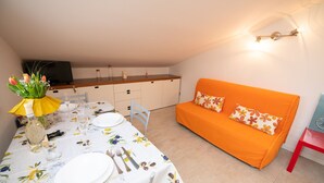 Un espacio habitable compacto con comedor y sofá.