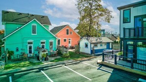 Une rangée de maisons aux couleurs vives, avec un parking au premier plan.