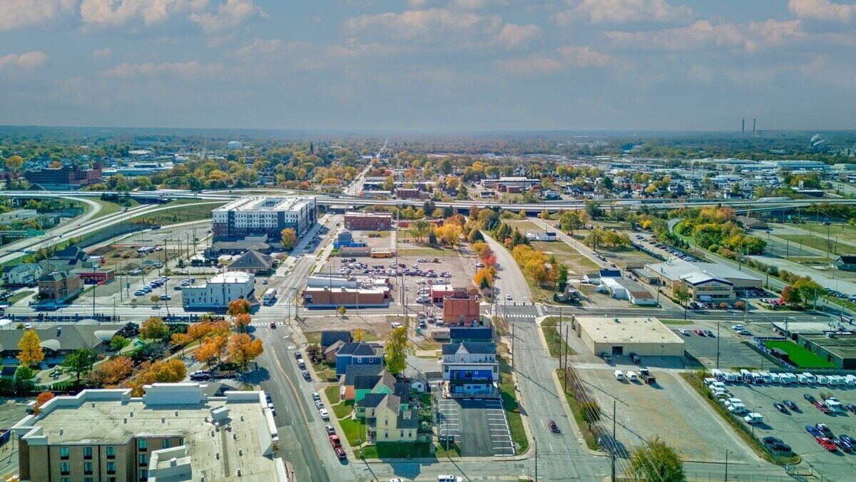 Vista aerea di una città con edifici commerciali, parcheggi e strade.