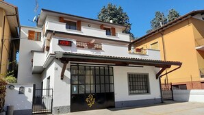 A two-story building with a white facade, a black gate with a lion emblem, and a digital display showing "+29". - Casa el Paso in Padenghe sul Garda (Padenghe sul Garda)