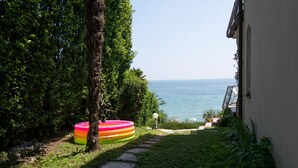 A garden with a view of the sea, a tree, and a colorful inflatable pool. - Villa Lydia in Padenghe sul Garda (Padenghe sul Garda)