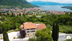 Un quartier résidentiel où se trouve une maison remarquable, avec un toit en tuiles, entourée d’une végétation luxuriante et d’arbres.