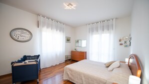 Een slaapkamer met een bed, een kaptafel en een stoel.