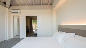 A bedroom with a large bed, a ceiling fan, and an air conditioning unit. - L Agrumeto - Il Pompelmo (Manerba del Garda)