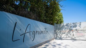 Un mur blanc sur lequel est inscrit en noir le nom « L’agrumeto ».