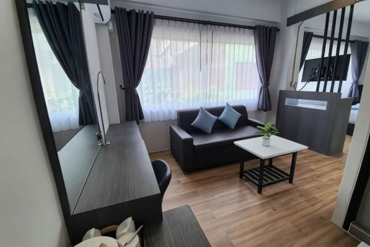 A modern living room with a sofa, a coffee table, and a TV.