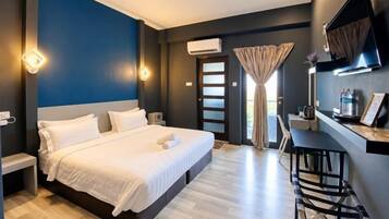 A hotel room with a bed, bedside tables, a desk, and a chair.