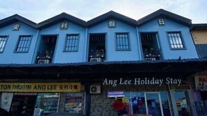 A building with a blue facade and multiple windows. There is a sign that reads "Ang Lee Holiday Stay" and another sign with Chinese characters. - Ang Lee Holiday Stay (Semporna)