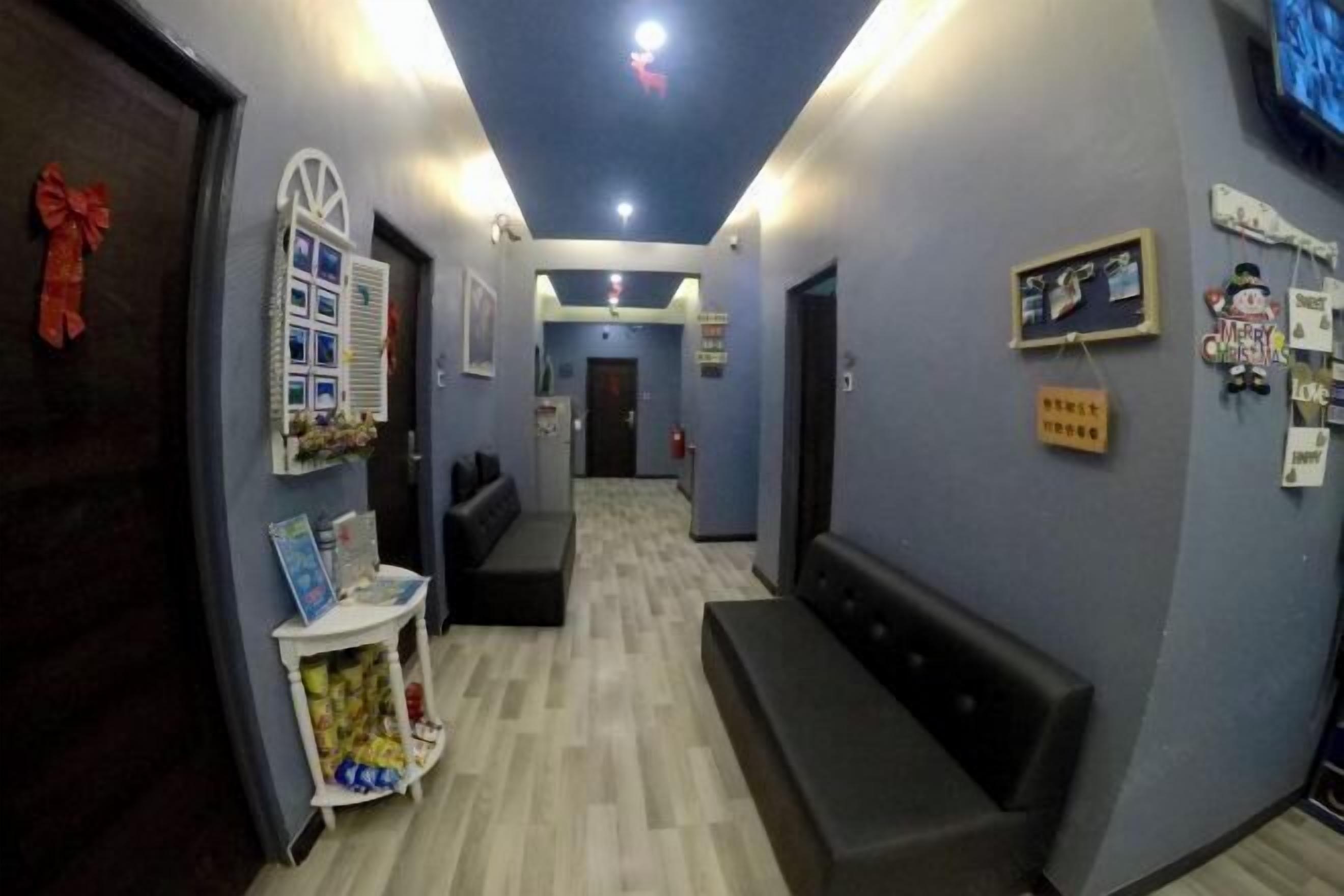 A hallway with a reception desk, a bench, and a wall with holiday decorations.
