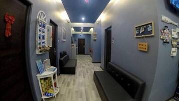 A hallway with a reception desk, a bench, and a wall with holiday decorations.