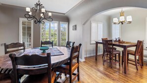A dining area with a wooden table, chairs, and a chandelier. - Spanish Villa Style With Luxury Furniture & Yard! (Los Angeles)