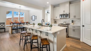 A spacious kitchen with a central island, wooden flooring, and white cabinetry. - Crimson Ridge 1373, SLP 20, Private Pool, Game Room, Mountain Views, and Resort Access (Washington)