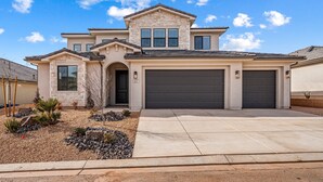 A two-story house with a stone facade, a garage, and a landscaped front yard. - Crimson Ridge 1373, SLP 20, Private Pool, Game Room, Mountain Views, and Resort Access (Washington)
