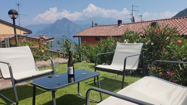 An outdoor seating area with two chairs and a table, a bottle of wine, and two glasses. - BLONDIE HOUSE (Fonteno)