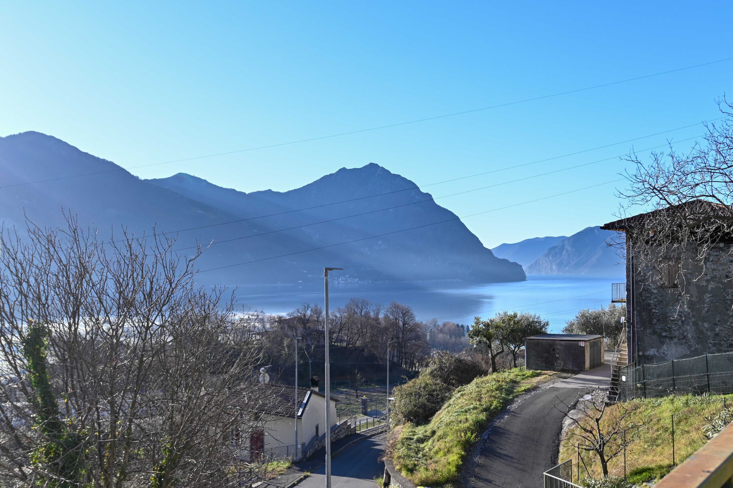 A mountain landscape with a clear sky, a road, and a small building.