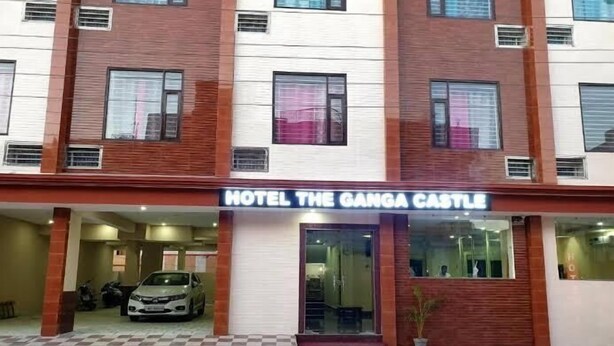 A hotel named "Hotel The Ganga Castle" with a checkered floor pattern, large windows, and a visible car parked in front. - Hotel The Ganga Castle (Haridwar)