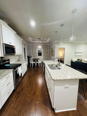 Enjoy cooking in this well-equipped kitchen with a stainless steel sink, microwave, and ample dining space.
