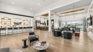 A spacious living area with a dining bar, modern furniture, and a view of the outdoors. - Private Estate-Waterslide-Theatre-Sauna-Pickleball (Indio)
