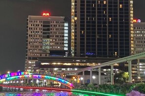 A nighttime cityscape with illuminated buildings and a brightly lit bridge. - The Pines by Amanjiwa (Melaka)