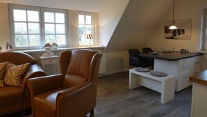 Un appartement moderne de style « loft » comprenant un coin repas, une cuisine et un salon.