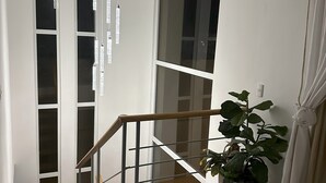 Ein modernes Interieur mit Treppe, Blumentopf und Pendelleuchten.