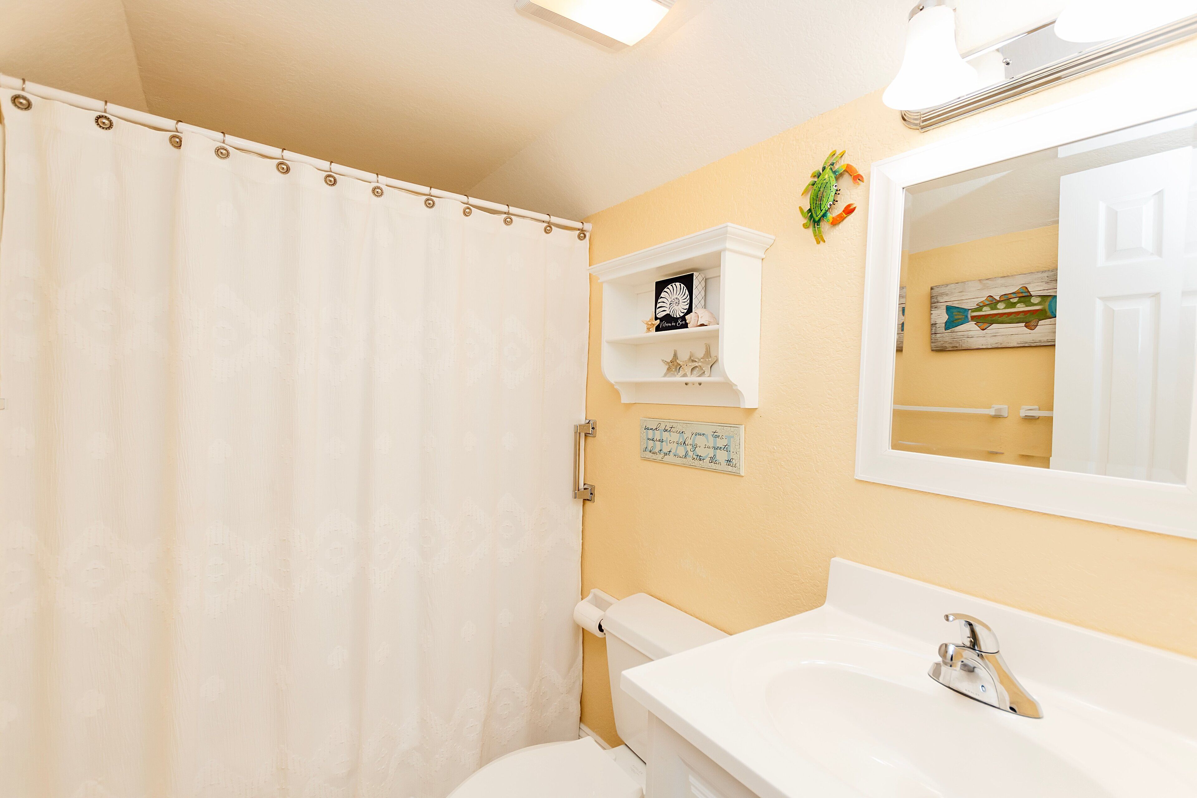 Een badkamer met toilet, wastafel en douchegordijn.