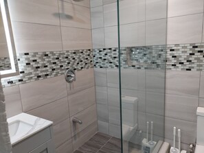 Een douche, handdoeken, zeep, toiletpapier