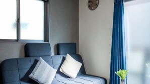 A room with a sofa, pillows, a clock, a window, and a curtain. - Shishinkaku (Kyoto)