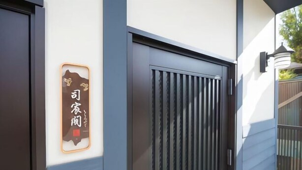 A building entrance with a dark door and a sign with Japanese characters. - Shishinkaku (Kyoto)