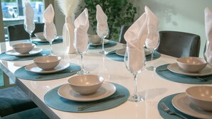 Une table à manger dressée avec des bols, des verres et des serviettes.