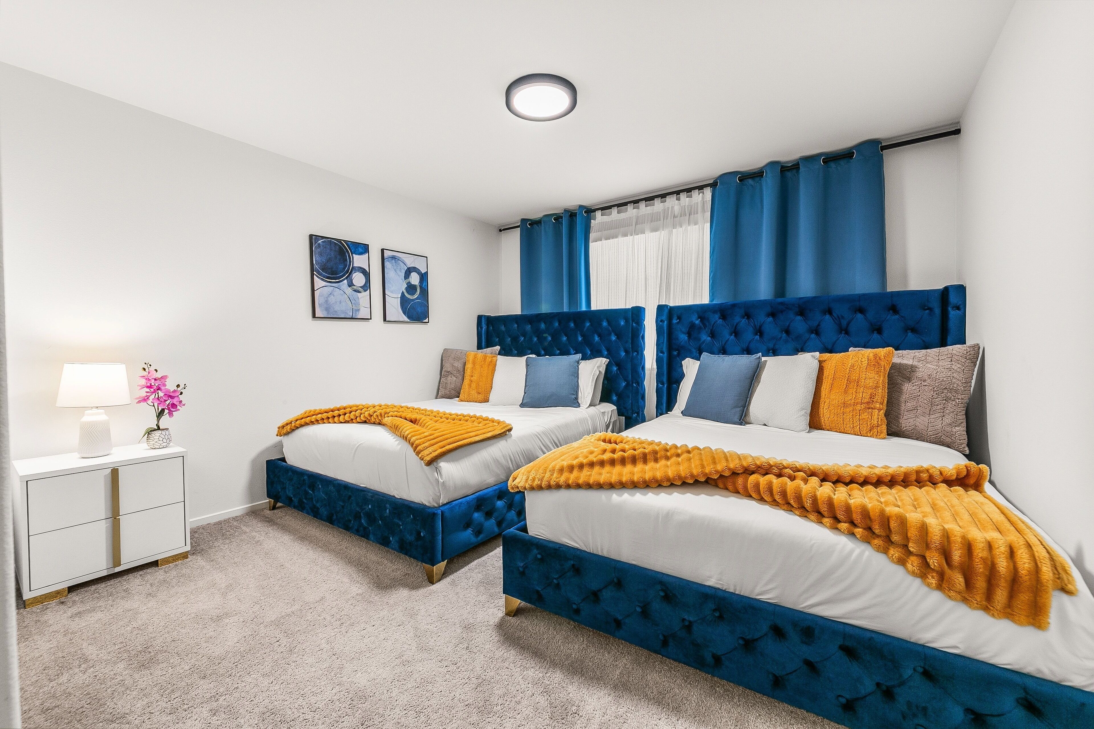 Een slaapkamer met twee bedden, een nachtkastje en een lamp.