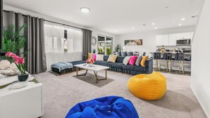 Un salon moderne avec un canapé, une table basse et un fauteuil poire.