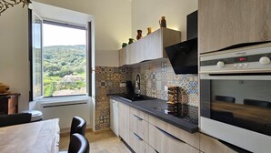 Una cocina moderna con un ventanal grande, un salpicadero con diseño y electrodomésticos integrados.