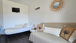 A room with a bed, a sofa, a TV, and a decorative mirror. - T2 Dolce & Vita C5 sea and pool view (Propriano)