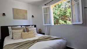 A bedroom with a bed, a window, and a wall-mounted artwork. - T2 Dolce & Vita C5 sea and pool view (Propriano)