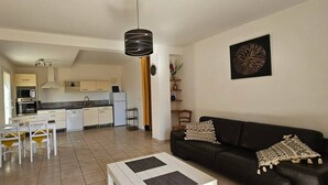 A modern apartment with a kitchen, dining area, and living room.