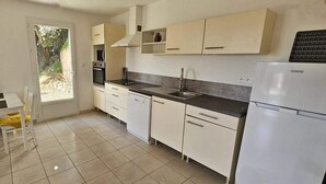 A kitchen with white cabinets, a black countertop, and a built-in oven.