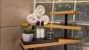 A wooden shelf with toiletries, a potted plant, and a sign indicating a Romarin soap bar. - Peaceful T3 in Vigna Maggiore, Olmeto (Olmeto)
