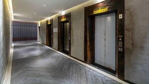 A hallway with four elevators, each marked with a sign indicating their floor number. - 3-bedroom Oasky Vung Tau with Partial Ocean View (Ho Chi Minh City)